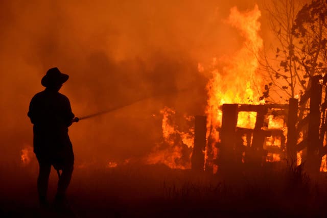 Residents attempt to defend a property from a bushfire near Taree, 350km north of Sydney