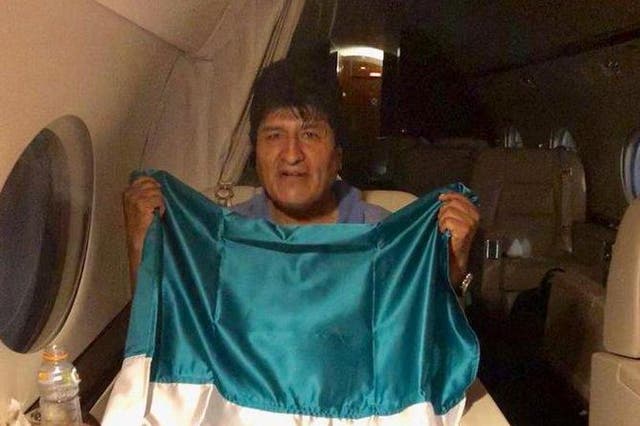 Evo Morales holds the Mexican flag as he flees his country