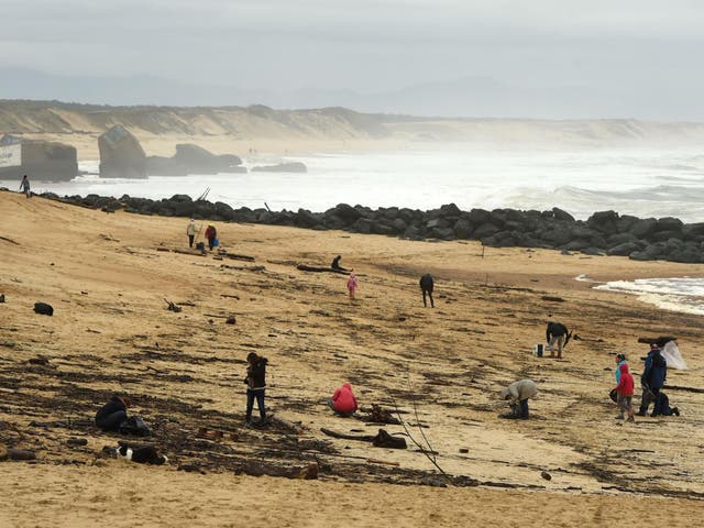 People walk on the beach in Capbreton, southwestern France, where cocaine packages have been found this week