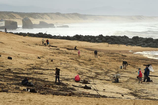 People walk on the beach in Capbreton, southwestern France, where cocaine packages have been found this week