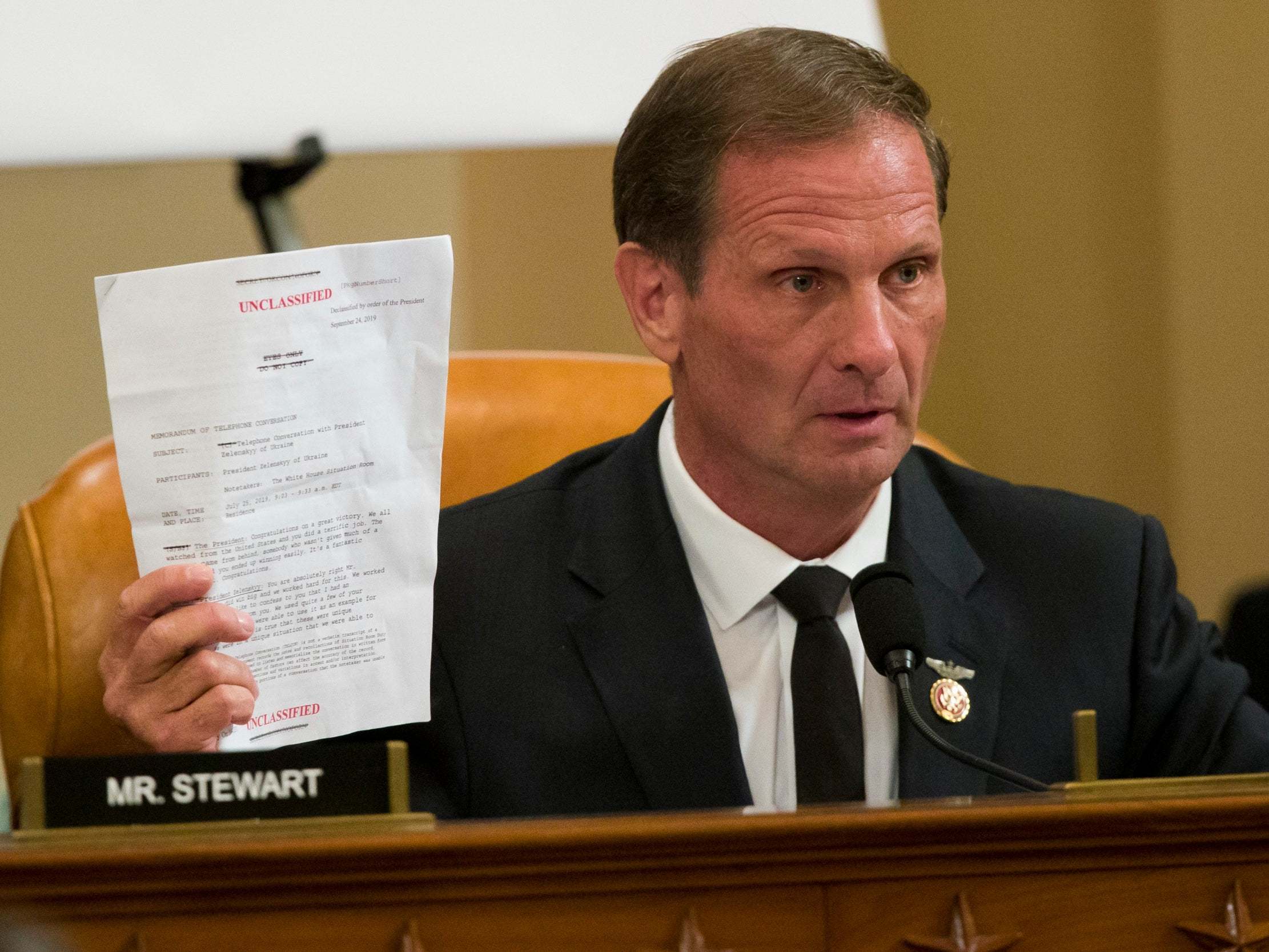 Rep. Chris Stewart, R-Utah, holds up the transcript summary of the call between Trump and Zelenskiy