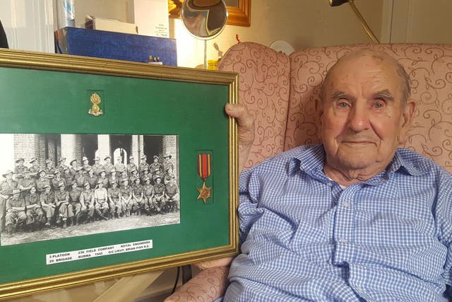 Brian Fish, who was left on a trolley in A&E for 10 hours, holds a picture of hos Royal Engineers platoon