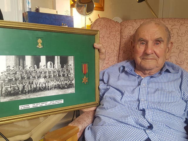 Brian Fish, who was left on a trolley in A&E for 10 hours, holds a picture of hos Royal Engineers platoon