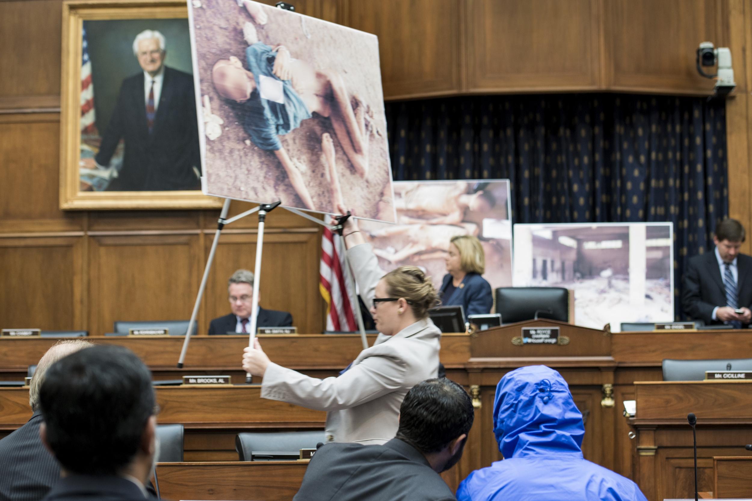 Syrian Army police photographer defector known as "Caesar" (C-blue jacket) waits to brief the House Foreign Affairs Committee on the torture and killing of anti-Assad regime activists on Capitol Hill in 2014