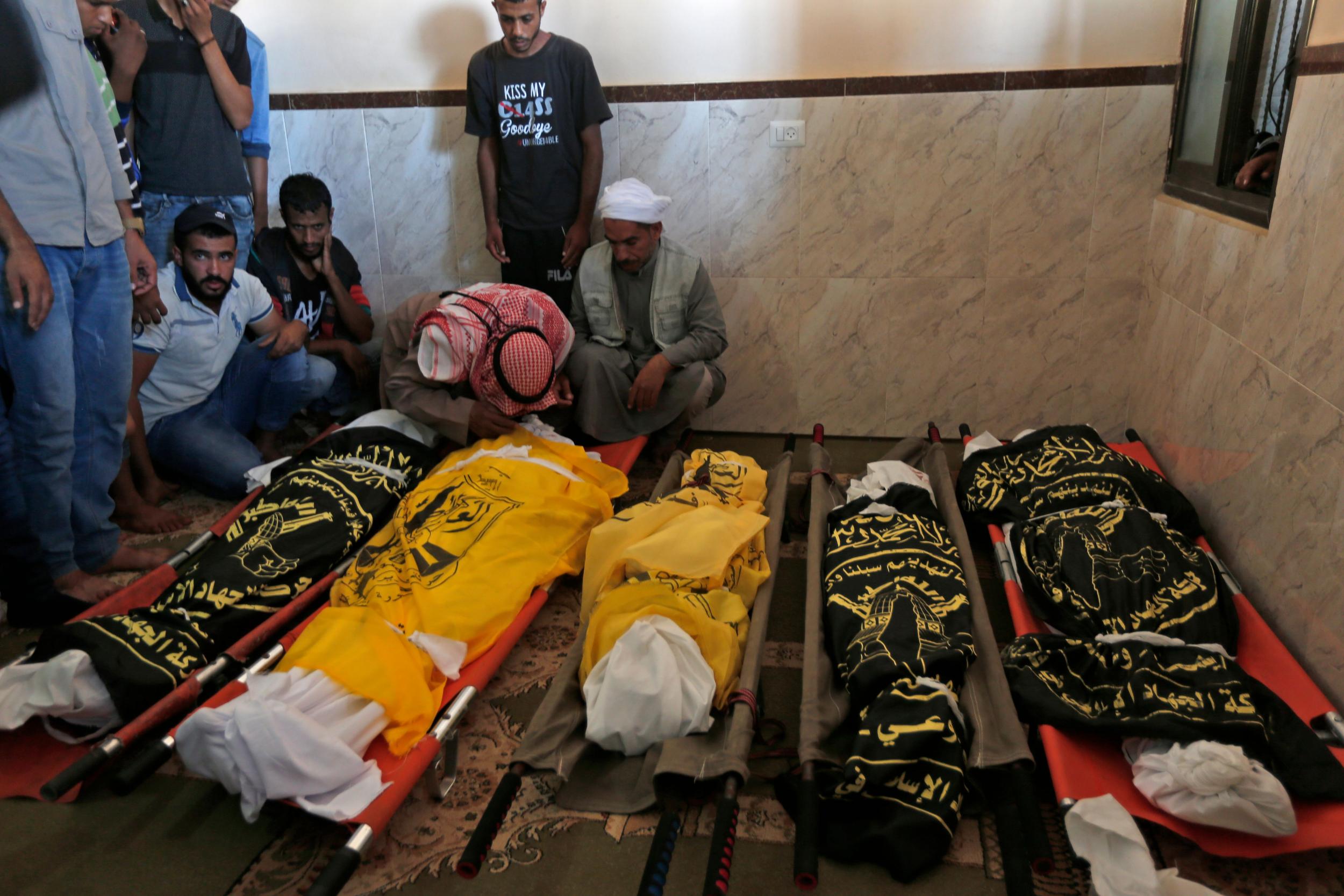 Palestinians mourn over the bodies of members of a family who were killed in an Israeli airstrike in Deir al-Balah