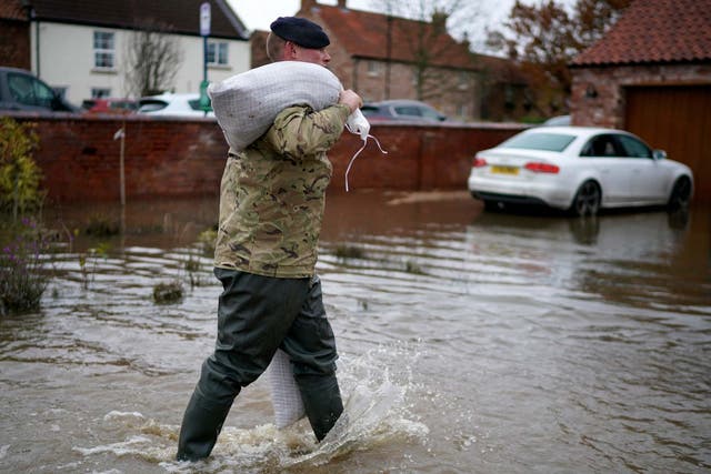 Soldiers help with sandbagging homes in the village of Fishlake