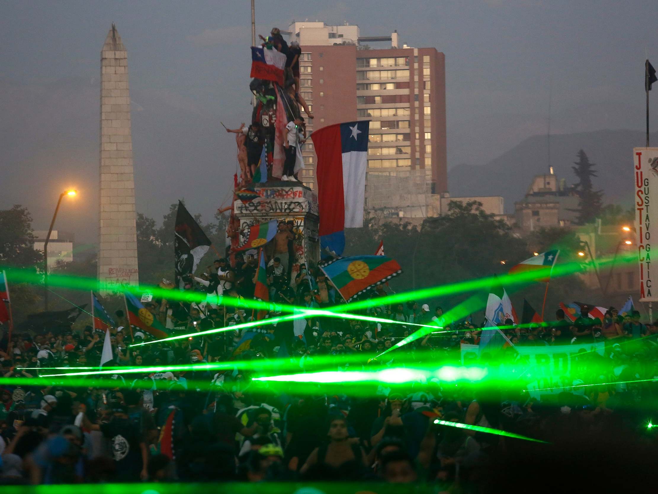 Protesters use lasers to tackle heavily armed police and bring down drone in Chile