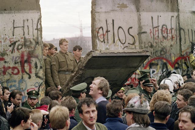 West Berliners watch East German border guards demolish a section of the Berlin wall on 11 November 1989