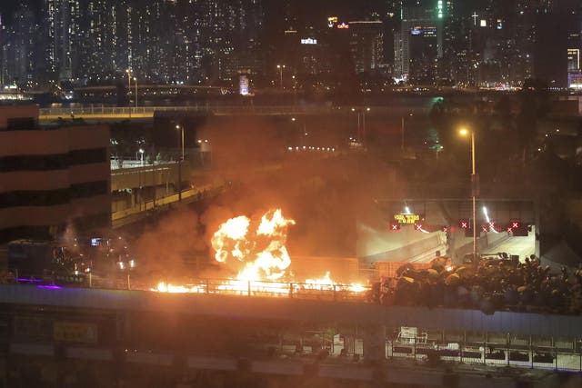 Protesters set alight a bridge separating them from riot police officers