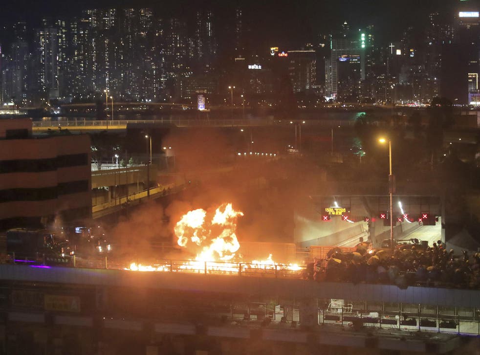 Protesters set alight a bridge separating them from riot police officers