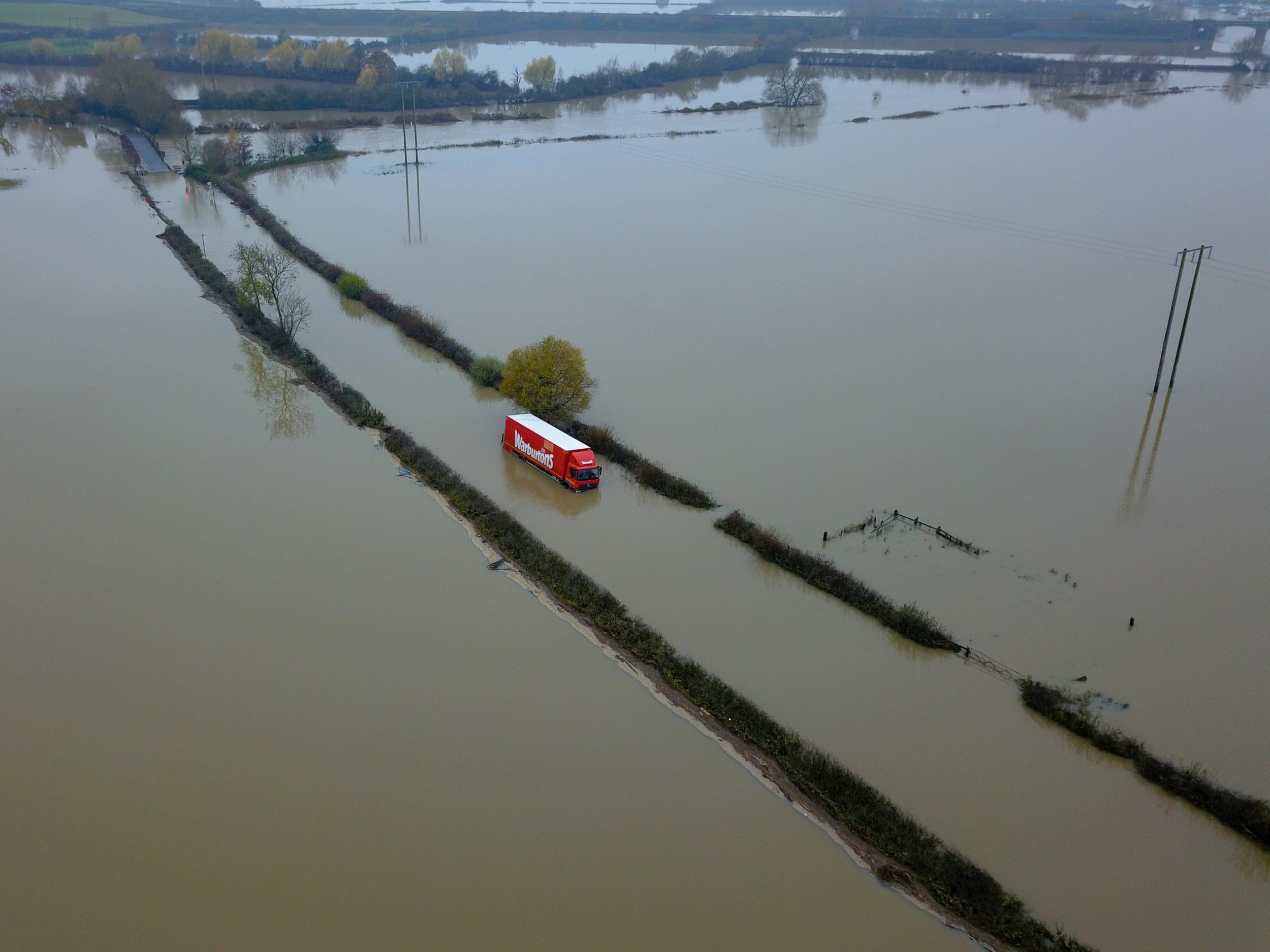 A lorry remains trapped in floodwater near the town of Pershore in Worcestershire