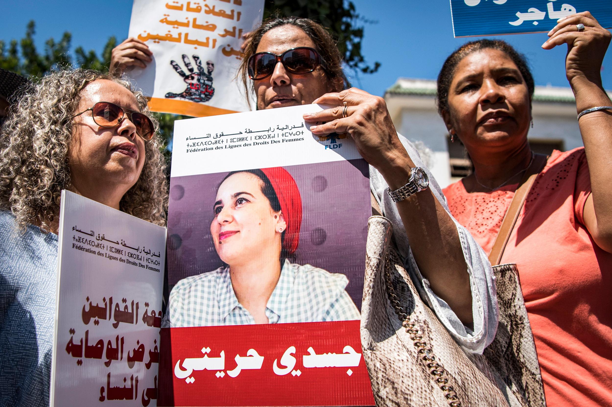 Demonstrators hold up a sign showing the portrait of Hajar Raissouni (AFP via Getty)