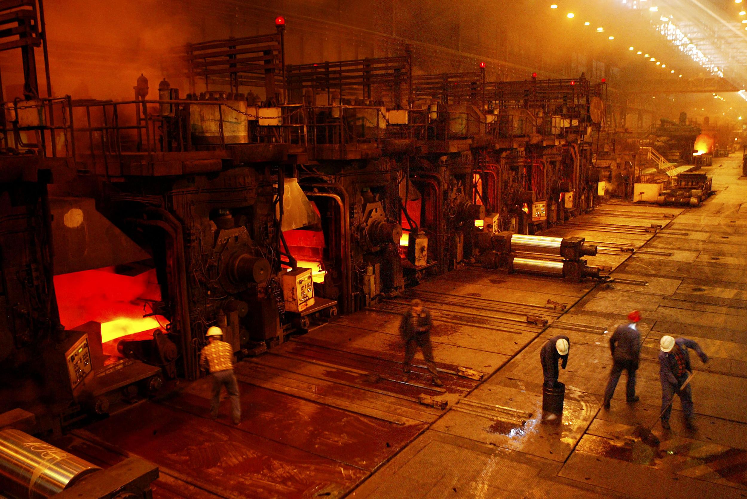 Workers clean the floors next to the hot rolling mill at the Sendzimir steel plant (Getty)