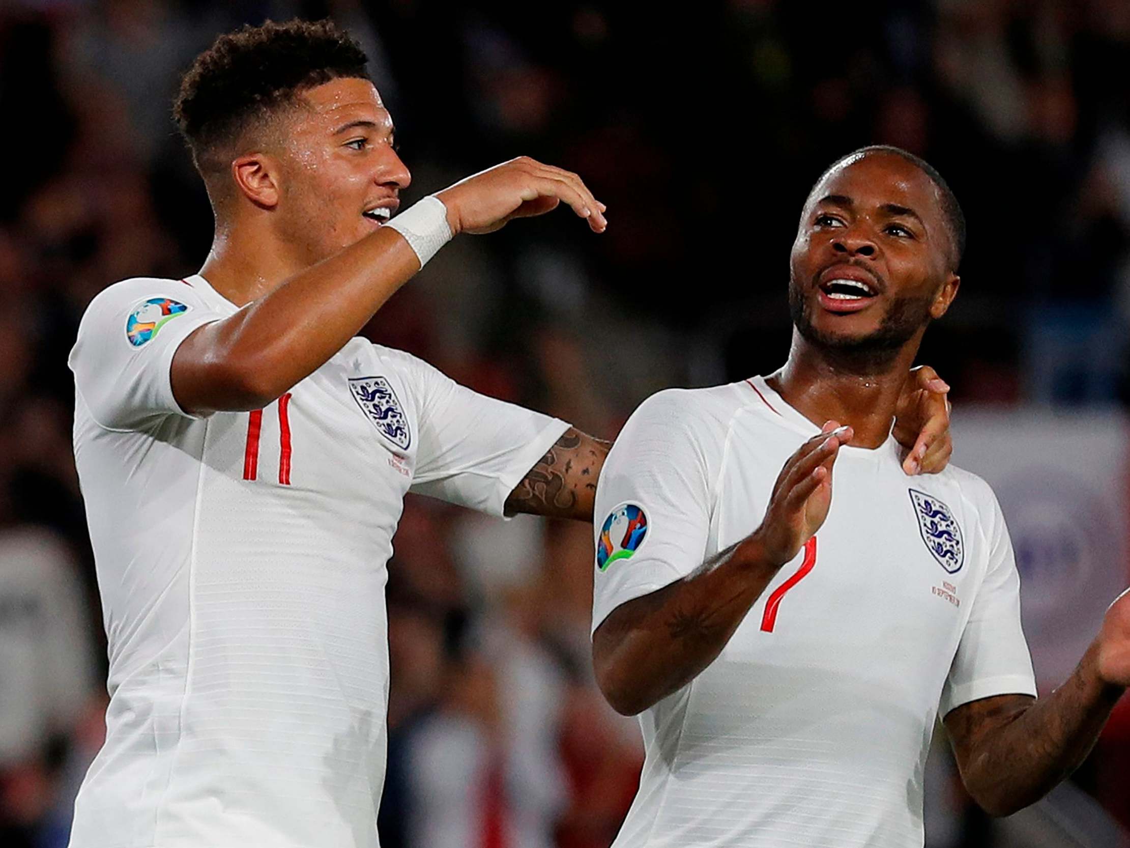 England midfielder Jadon Sancho celebrates with Raheem Sterling