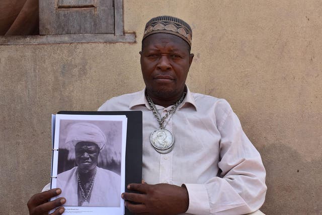 Paramount chief Kandeh Sorie Kakanday III with Northcote Thomas's photograph of his ancestor Almamy Suri Kakandeh in Sierra Leone