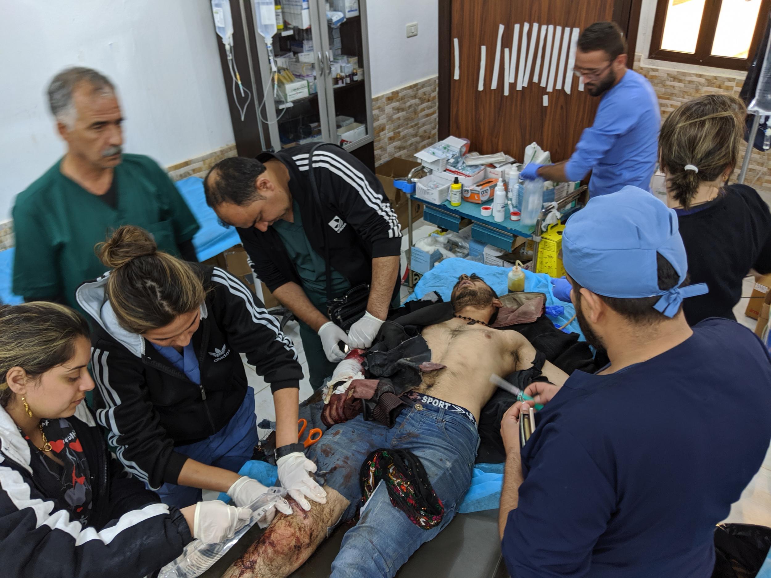 A man wounded by a mortar fire is brought into the emergency room at Tal Tamr hospital (Richard Hall/The Independent)