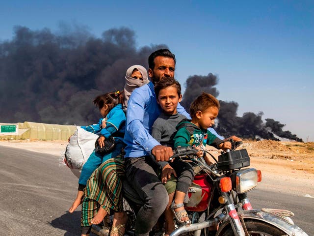 A Kurdish family flee the Syrian border city of Ras al-Ain