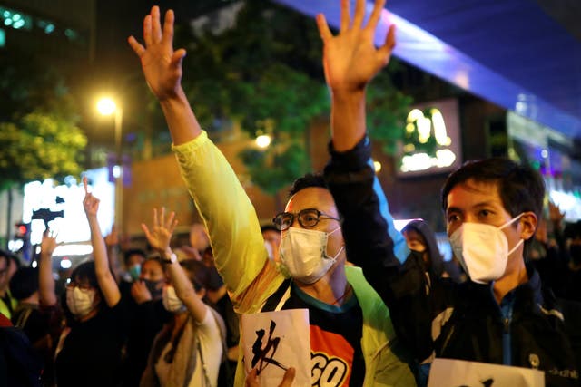 Protesters hold up five fingers outside the Polytechnic University in Hong Kong, representing the ‘five demands’ of the movement, after a resounding election victory for pro-democracy parties