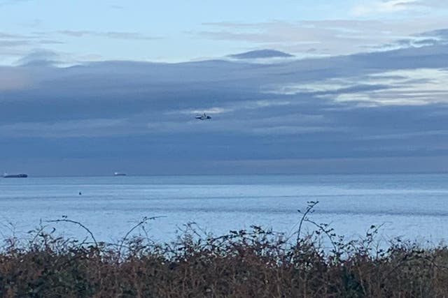 A helicopter joins the search following reports a light aircraft crashed in the sea near Anglesey