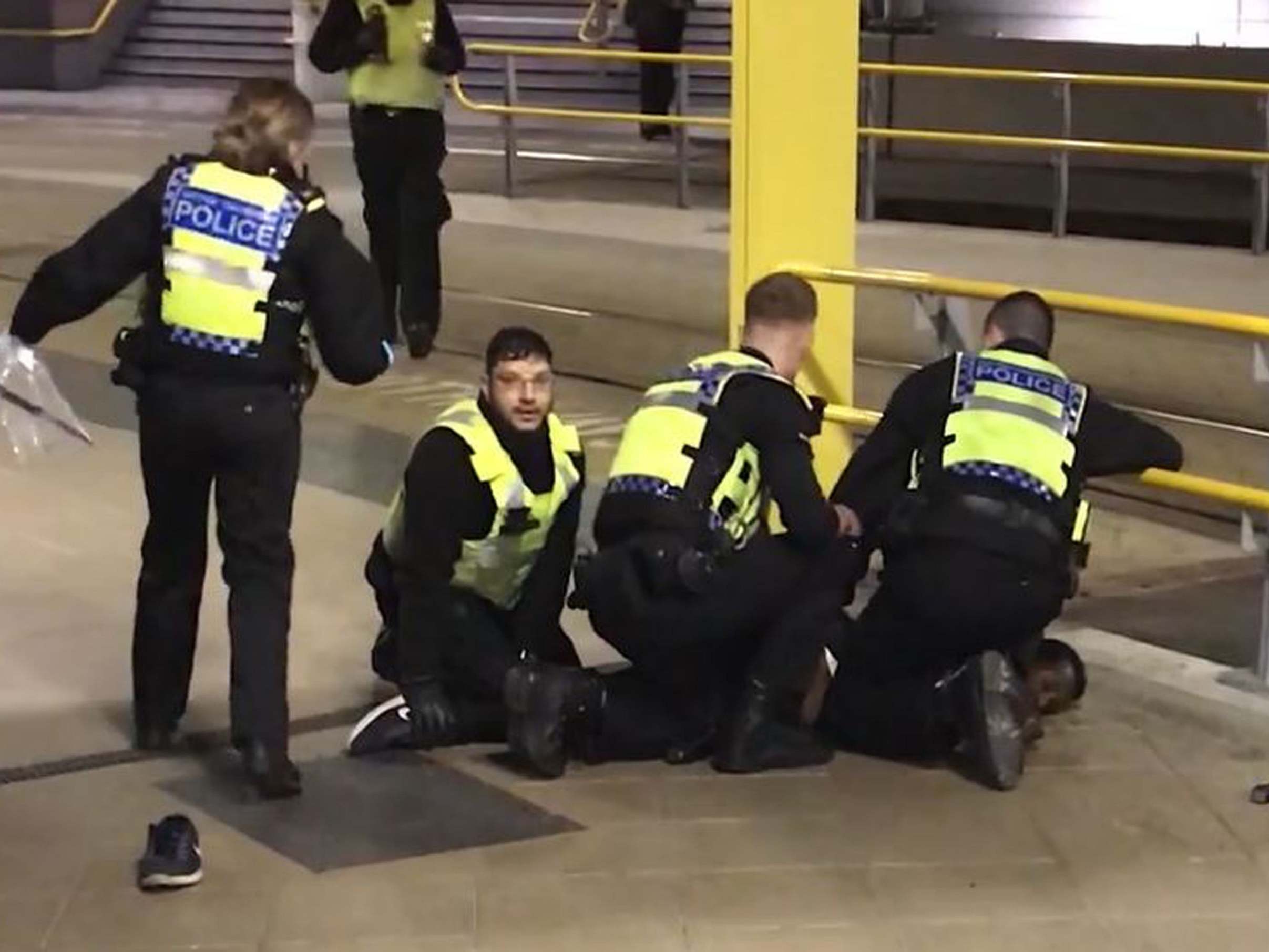 Police restraining Mahdi Mohamud after he stabbed three people at Manchester Victoria station on New Year's Eve