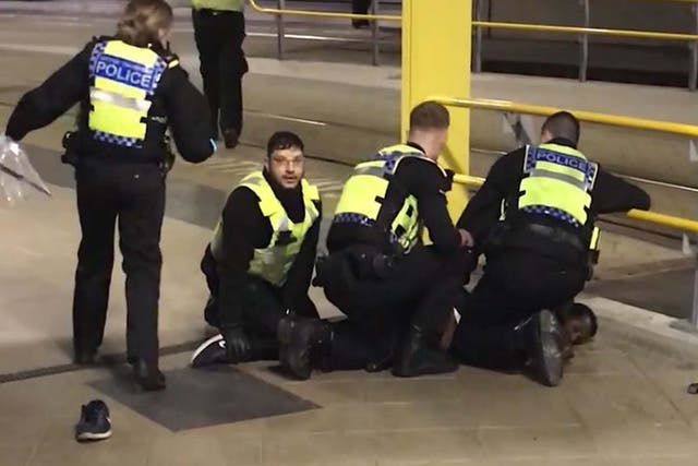 Police restraining Mahdi Mohamud after he stabbed three people at Manchester Victoria station on New Year's Eve