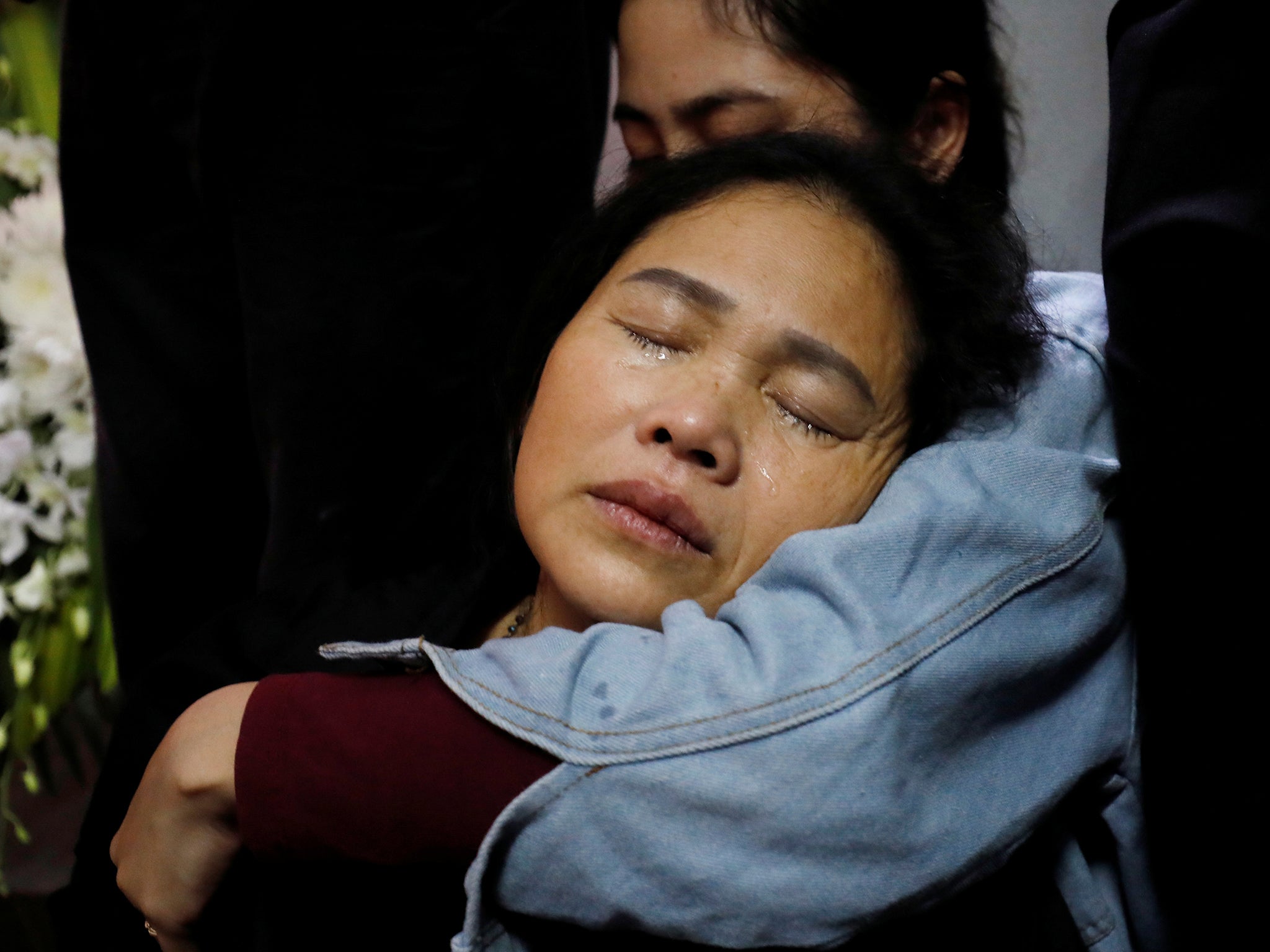 Anna Hoang Thi Ai, mother of Hoang Van Tiep, cries next to his body in Nghe An province