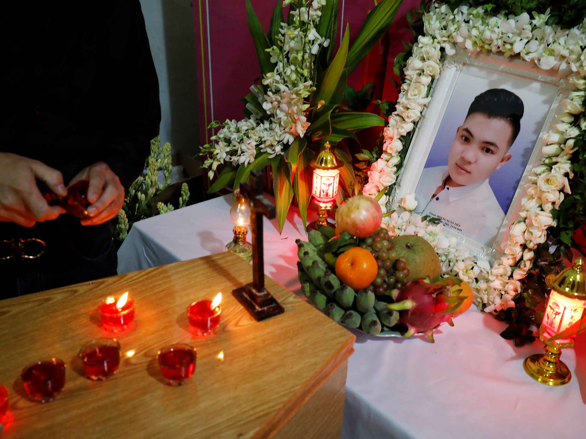A relative of Hoang Van Tiep lights a candle on his coffin