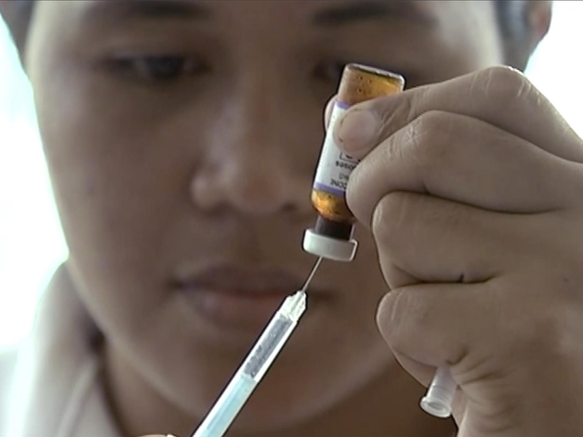 A New Zealand health official prepares a measles vaccination at a clinic.