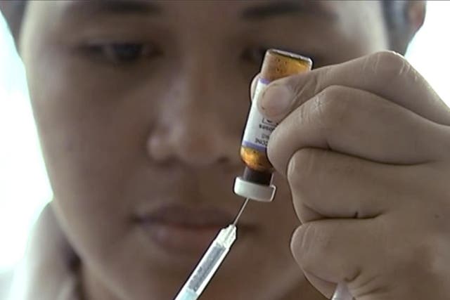 A New Zealand health official prepares a measles vaccination at a clinic.