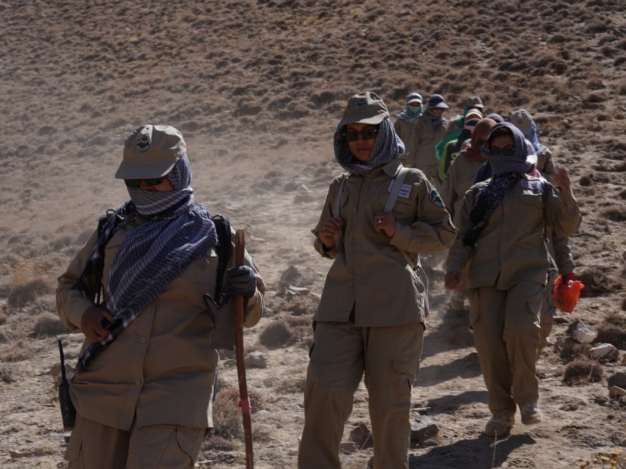 Women walk with the de-mining equipment in Bamyan