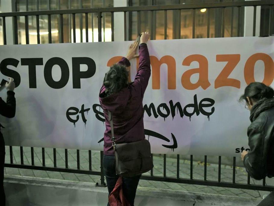 Protesters hang a sign reading ‘Stop Amazon and its world’ during anti Black Friday action in Clichy, France, on 29 November 2019