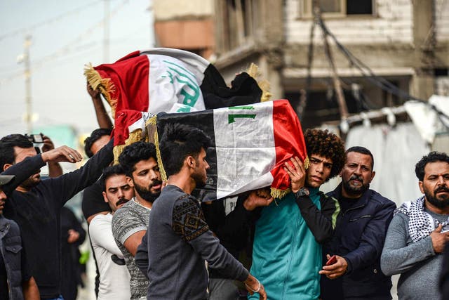 Mourners carry the coffin of a driver who was killed during clashes between anti-government protesters and security forces in Baghdad
