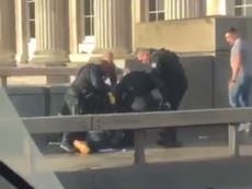 Bystanders wrestle suspect to floor before being dragged off by police
