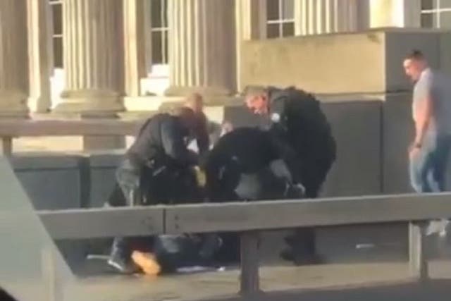 Still image taken from video of bystanders and armed police wrestling with suspected knifeman on London Bridge, 29 November 2019.