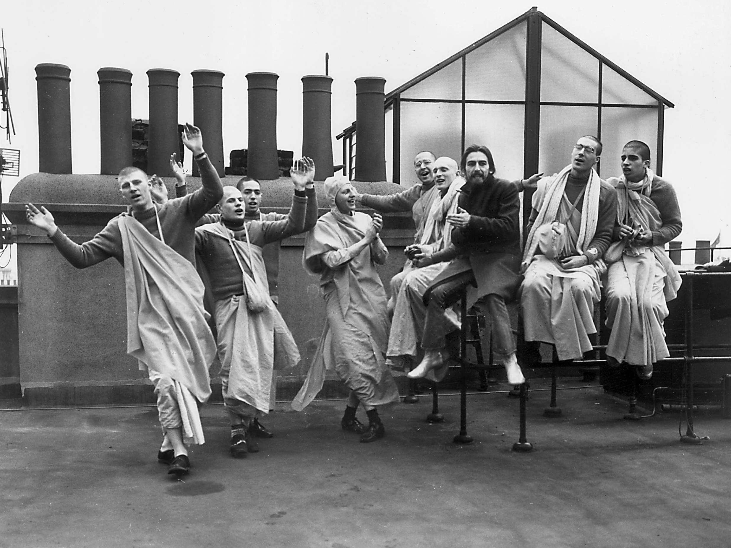 Geroge Harrison with his band of followers on a rooftop in 1970 (Getty)