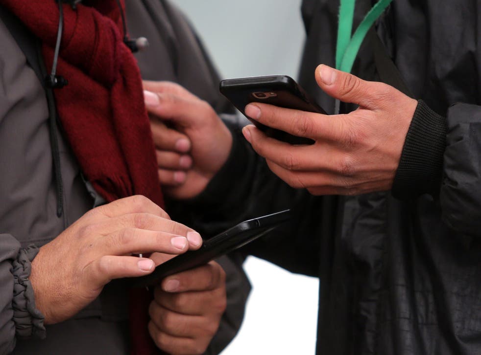 Iranians, pictured on their phones in Tehran, are struggling to adjust to life offline