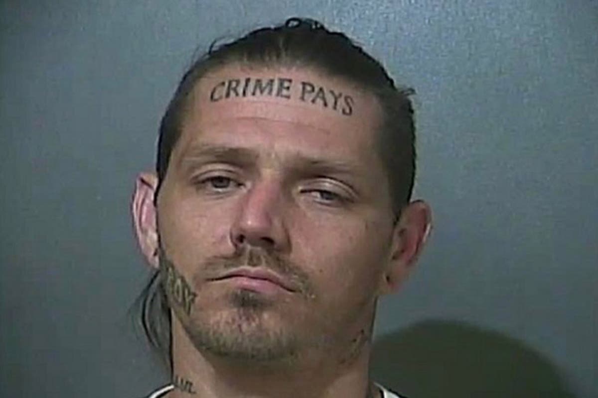 Police hunting man with 'crime pays' tattooed across his forehead