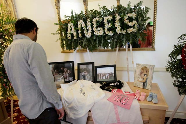 A person observes framed photographs of Rhonita Maria Miller and her four children, members of the Mexican-American Mormon community killed by unknown assailants, before her funeral in La Mora, in La Mora, Sonora state, Mexico 7 November 2019