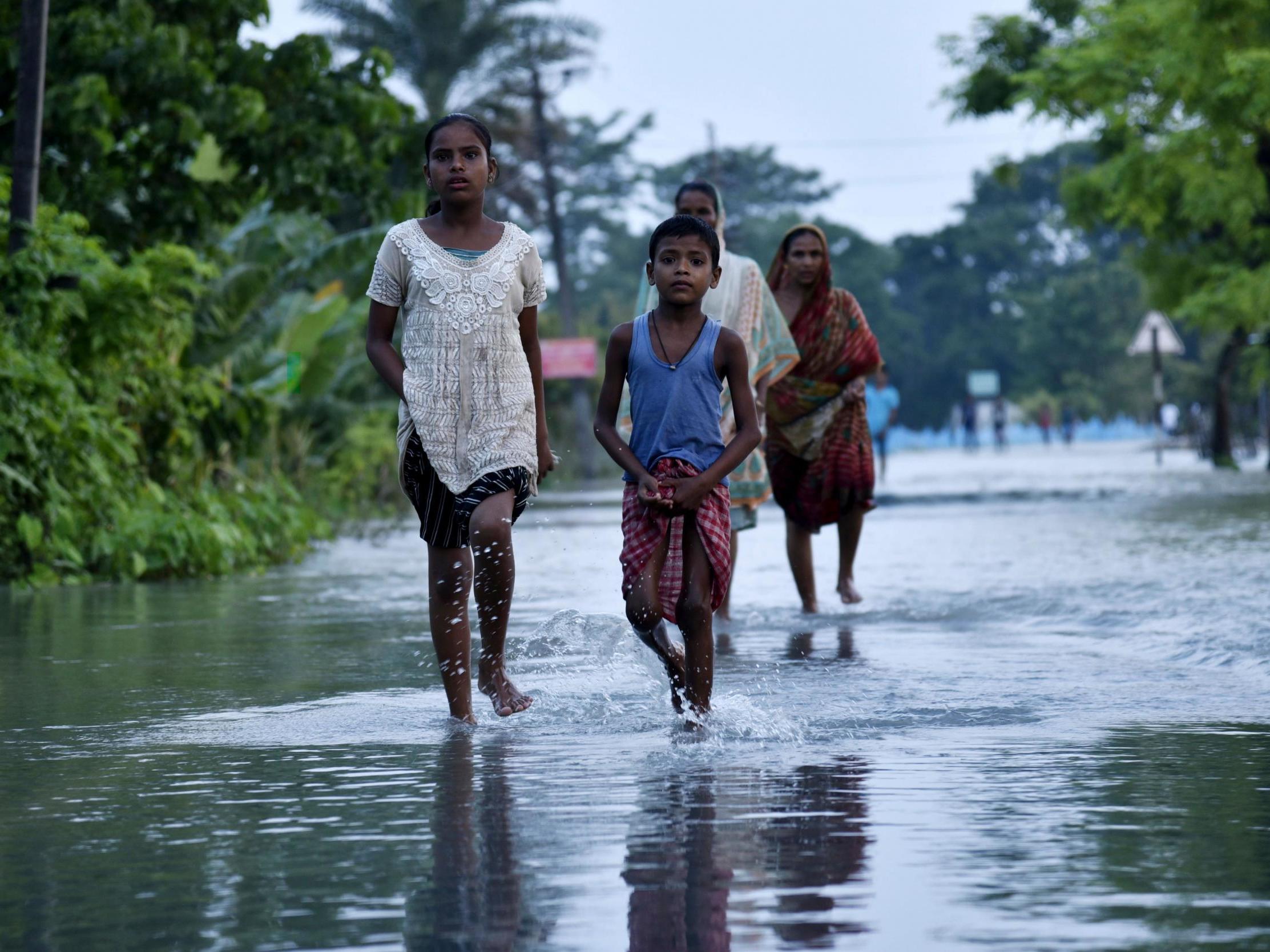 People walk through flood waters in India after a heavy monsoon this year