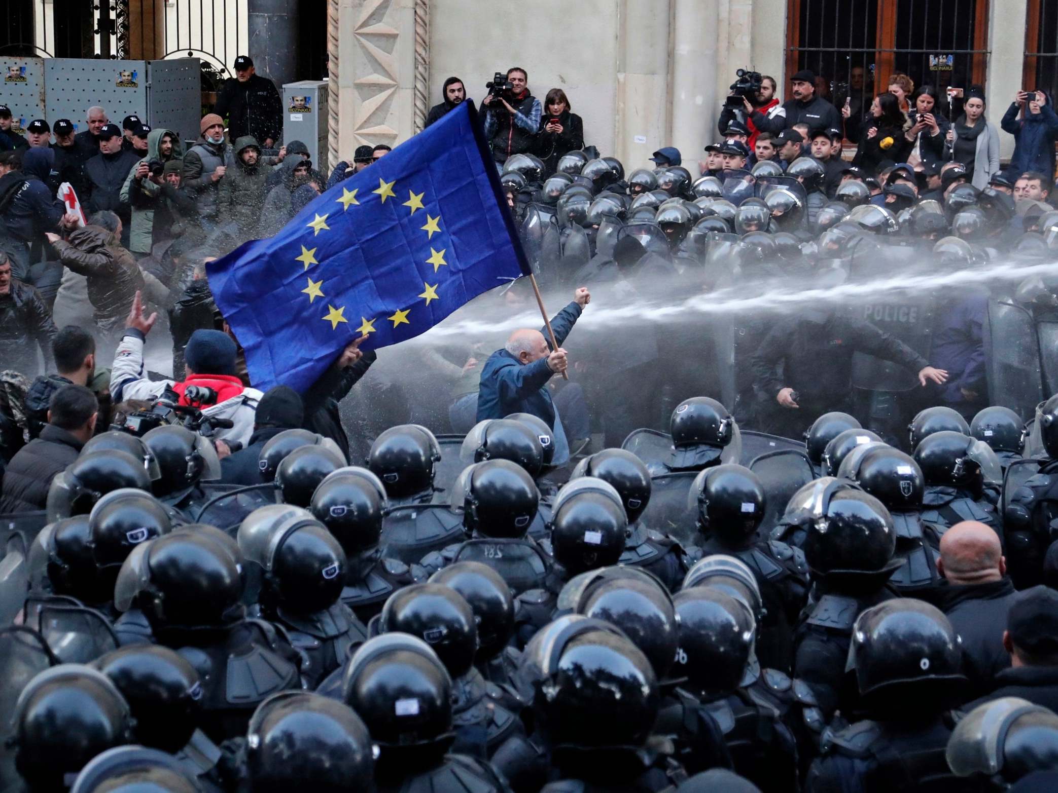 Riot police disperse opposition supporters during a protest rally in front of the parliament building in Tbilisi