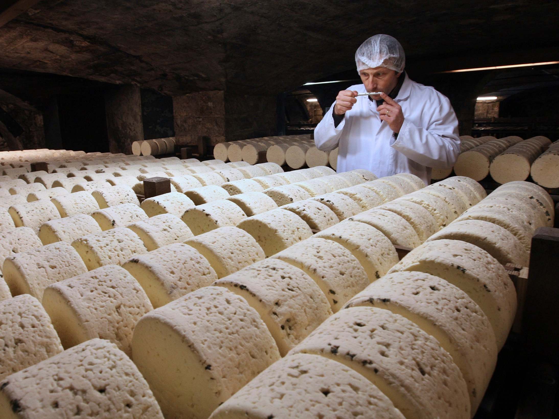 A refiner in a cellar in Roquefort, southwestern France, smells one of the village’s eponymous cheeses, which could be hit by new US tariffs