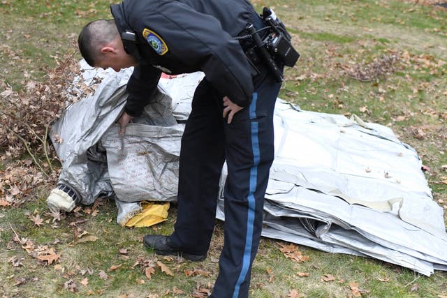 A police officer inspects an evacuation slide that fell from a jet into the garden of a home in Milton
