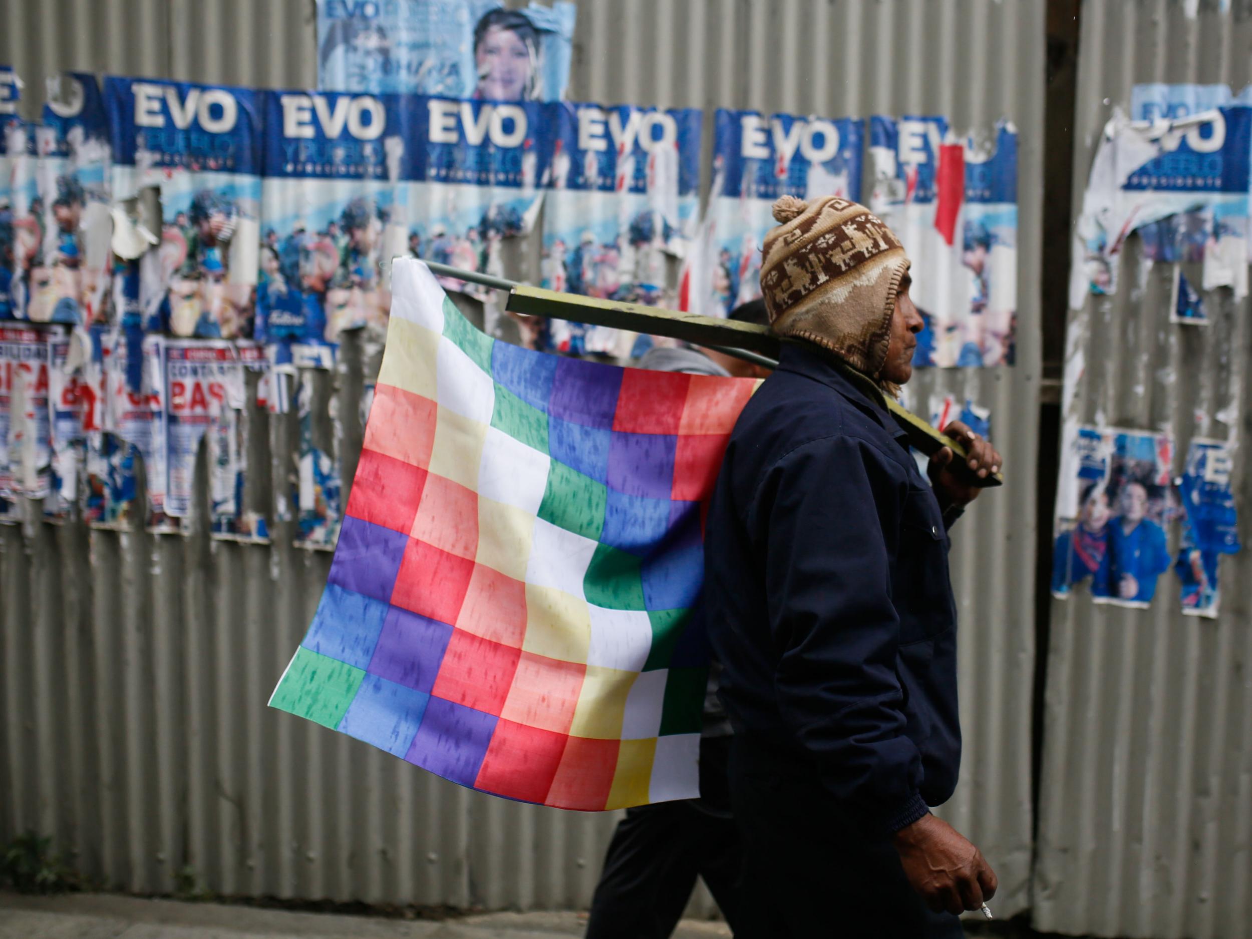 A supporter of Evo walks with a Wiphala flag during a La Paz protest