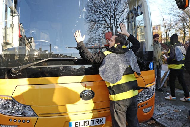 An Extinction Rebellion activist dressed as a giant bee glues himself to the windscreen of the Lib Dem battle bus