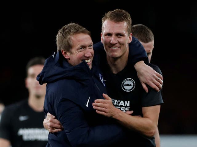 Graham Potter embraces Dan Burn after Brighton's victory over Arsenal