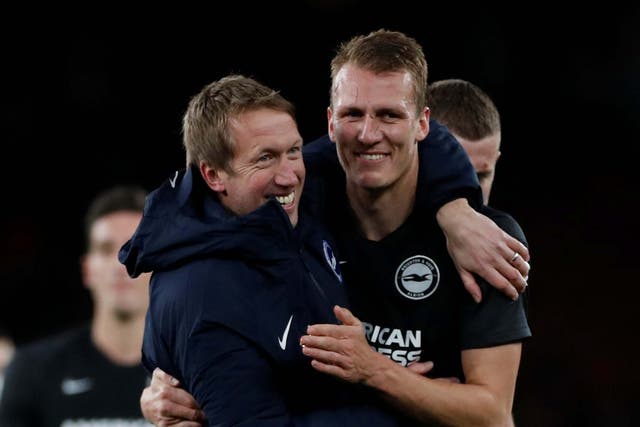 Graham Potter embraces Dan Burn after Brighton's victory over Arsenal