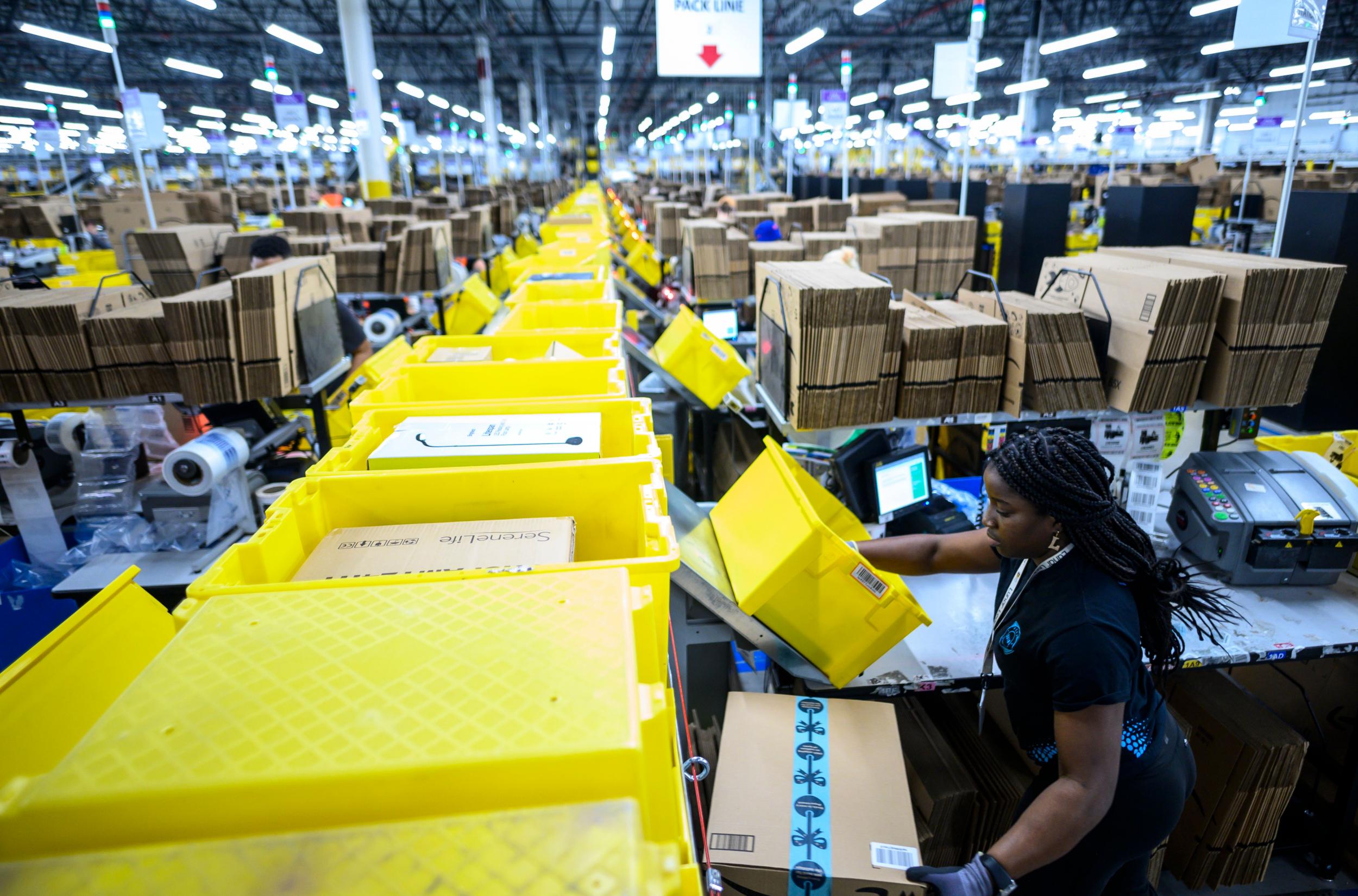 A woman works at a packing station at the 855,000-square-foot Amazon fulfilment centre in Staten Island (AFP/Getty)