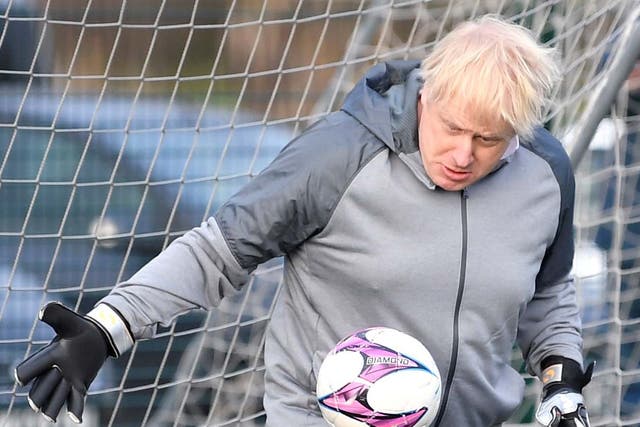 Boris Johnson takes a turn in goal during the warm up before a girls' soccer match