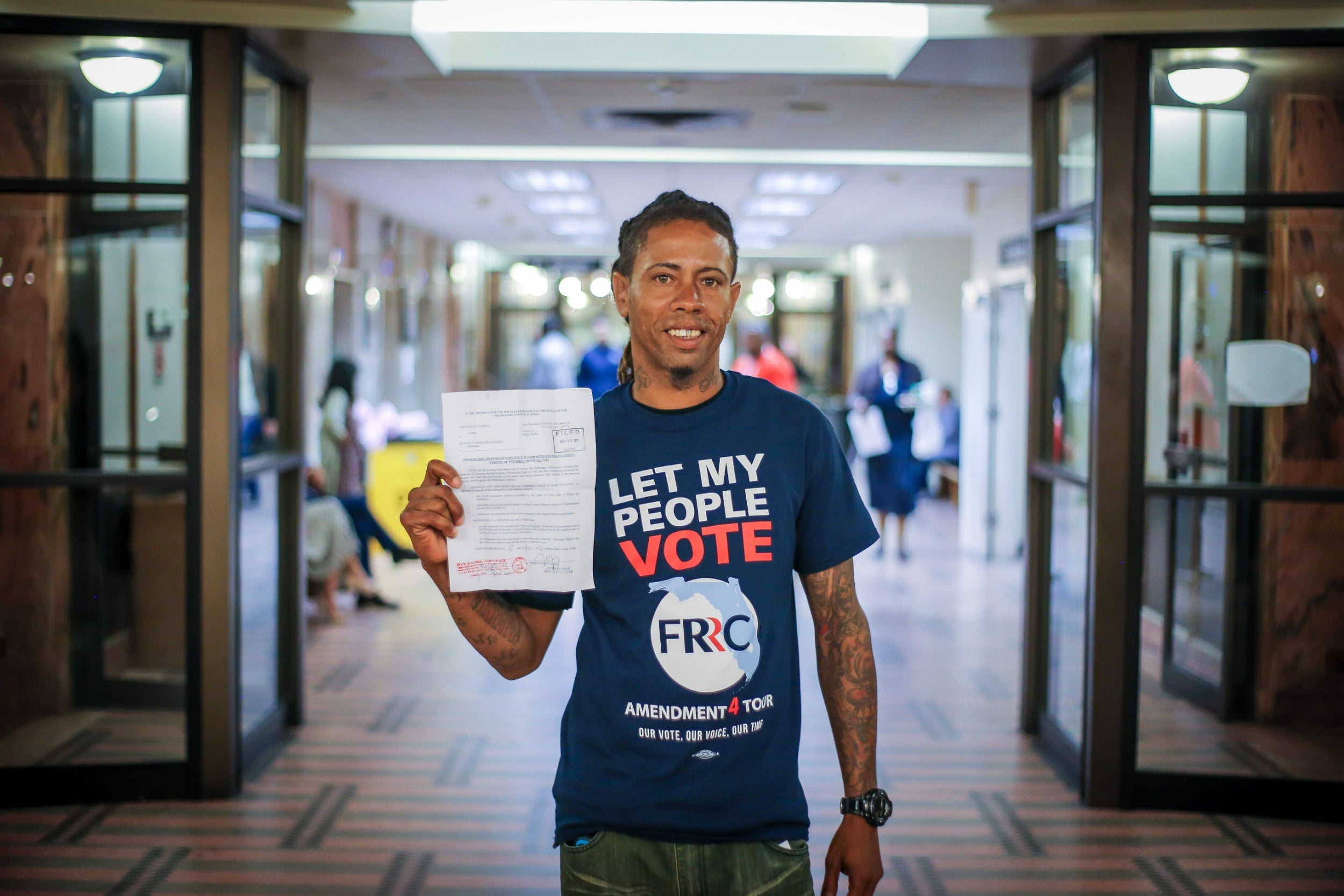 Michael Monfluery, a 38-year-old who has never been eligible to vote, shows off a certificate restoring his right after the special court hearing in Miami, Florida last month