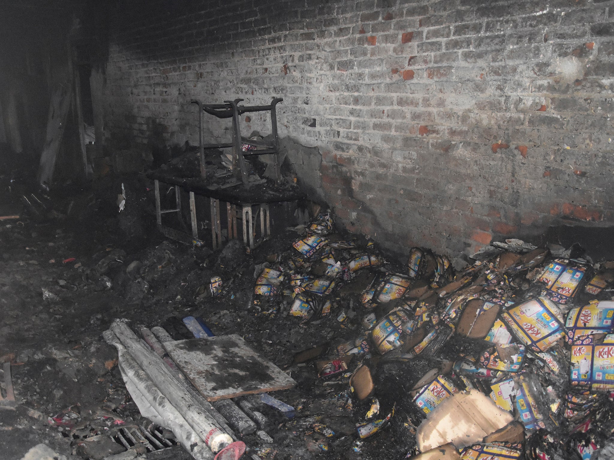 Charred goods remain in the factory space where the fire began